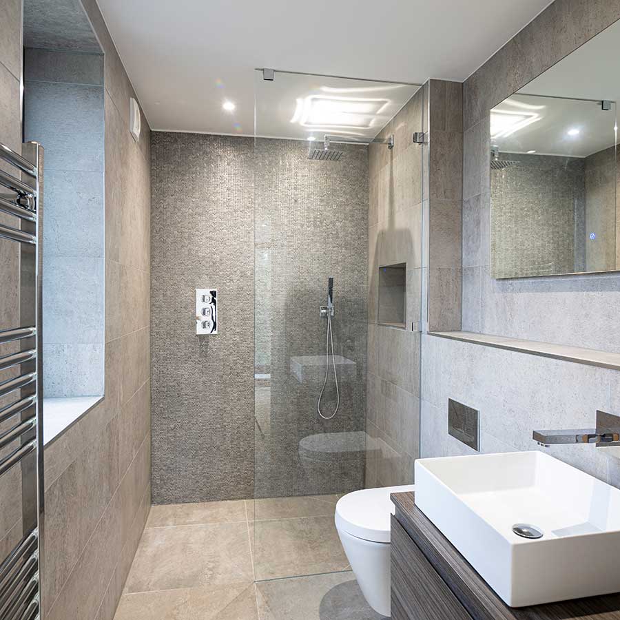 Large fixed frameless glass walk-in shower screen in a luxury ensuite bathroom in Cranford Cliffs Dorset
