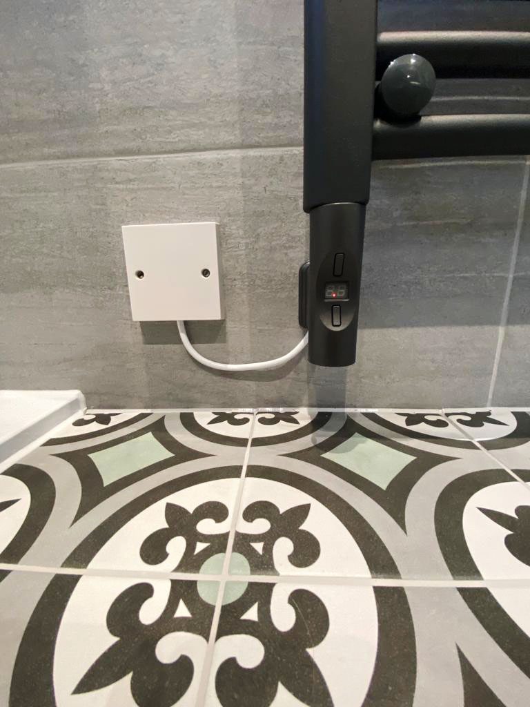 Lovely small pattern floor tiles contrast nicely with the stone grey wall tiles in this family bathroom installed for a customer in Dorset by Room H2o