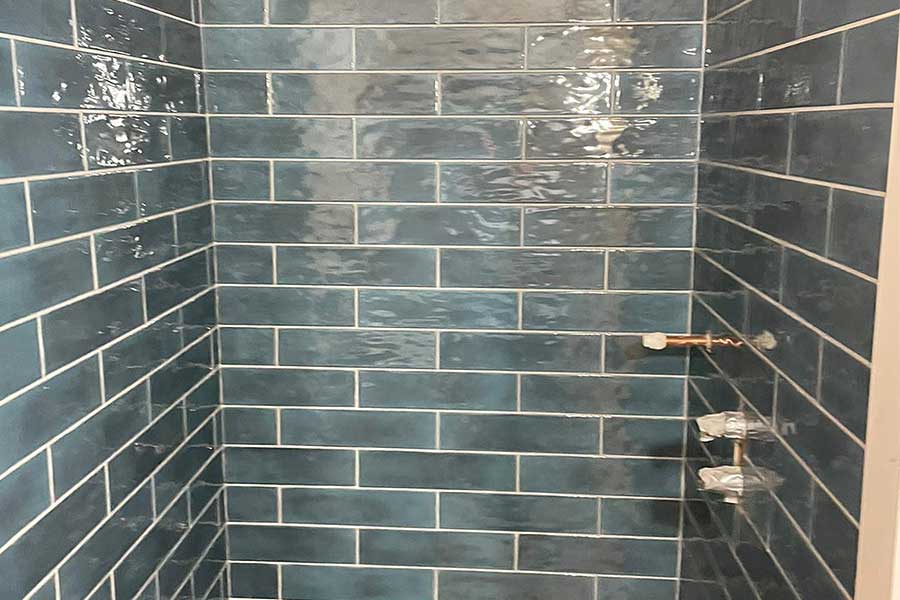 Aqua subway tiles installed in a shower by tilers from Room H2o in Dorset